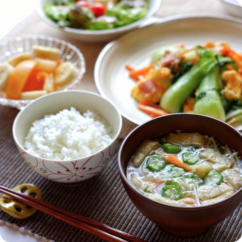 a plate of food with chopsticks and a bowl of rice