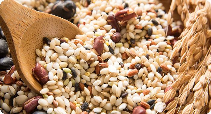 영양이 풍부한 혼합 잡곡과 나무 숟가락 (Nutrient-rich mixed grains with a wooden spoon)