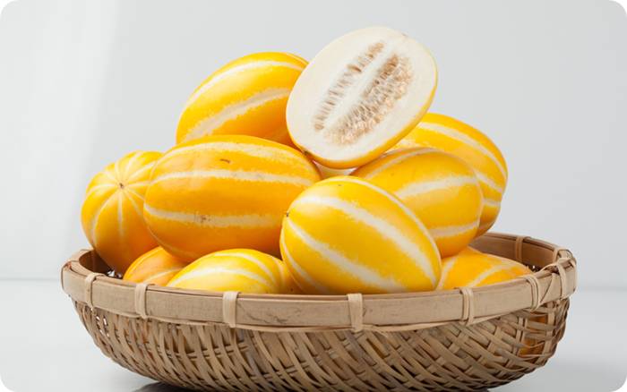 반으로 자른 참외와 바구니에 담긴 신선한 참외들 (Fresh Korean melons in a basket with one cut open to show inside)