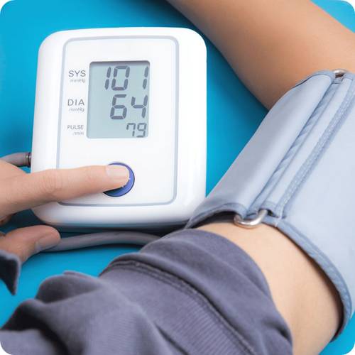 a person's hand pressing a blood pressure monitor